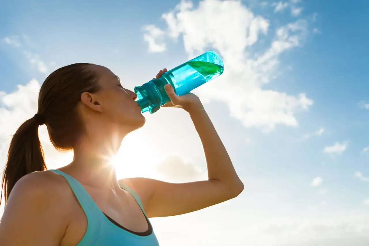 Scopri i segnali precoci della disidratazione e come evitarla in estate SC - Bicchiere d’acqua e sole estivo